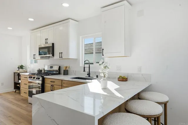 a kitchen with granite countertop white cabinets and a sink