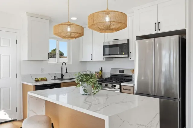 a kitchen with stainless steel appliances granite countertop a sink refrigerator and microwave