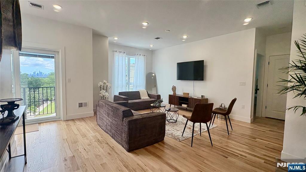 367 Devon Street, Unit 2 Kearny, NJ 07032 - Photo 3 of 30 a living room with furniture a wooden floor and a flat screen tv