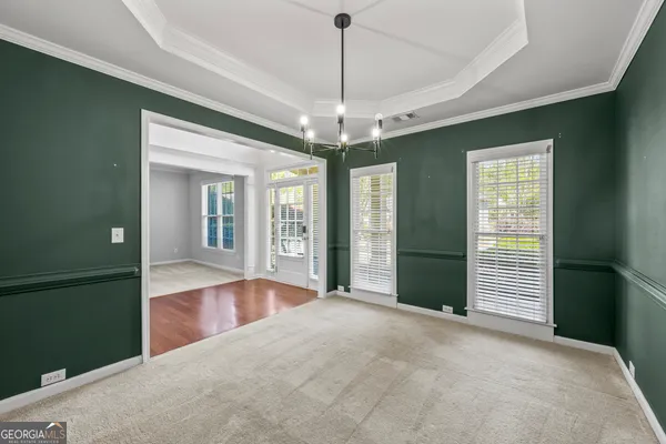 a view of a livingroom with a fireplace a ceiling fan and windows
