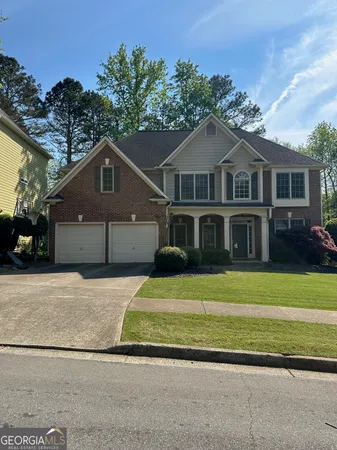 a front view of a house with a garden