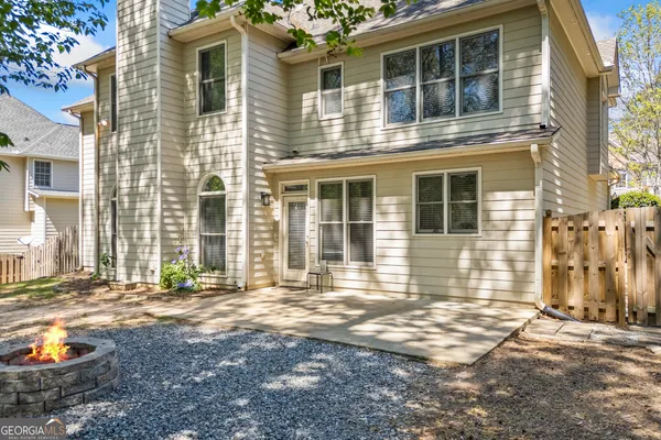 a view of a backyard with large trees and wooden fence