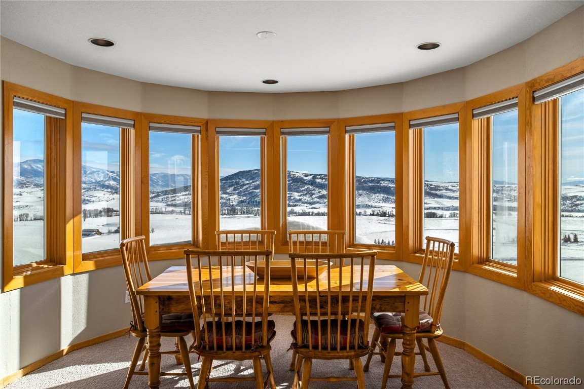 43750 Diamondback Way Steamboat Springs, CO 80487 - Photo 27 of 50 a view of a dining room with furniture large windows and wooden floor