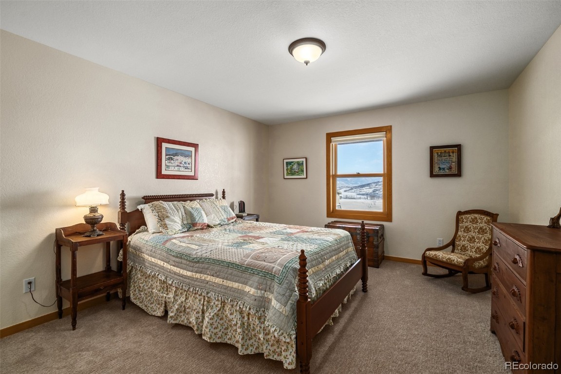 43750 Diamondback Way Steamboat Springs, CO 80487 - Photo 35 of 50 a bedroom with a bed and a chandelier