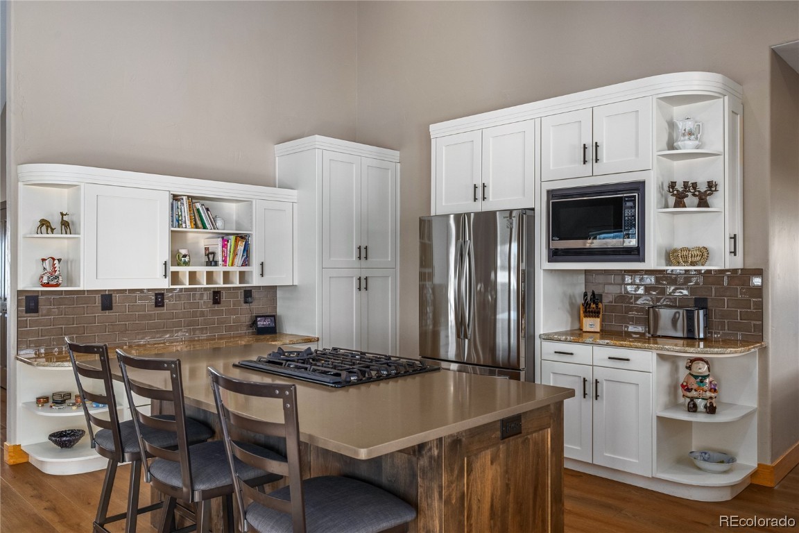 43750 Diamondback Way Steamboat Springs, CO 80487 - Photo 5 of 50 a kitchen with stainless steel appliances granite countertop a stove a refrigerator a sink a dining table and chairs