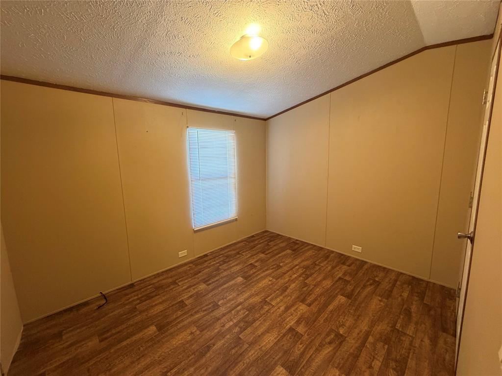 985 Indian Gap Quitman, TX 75783 - Photo 12 of 20 an empty room with wooden floor and windows