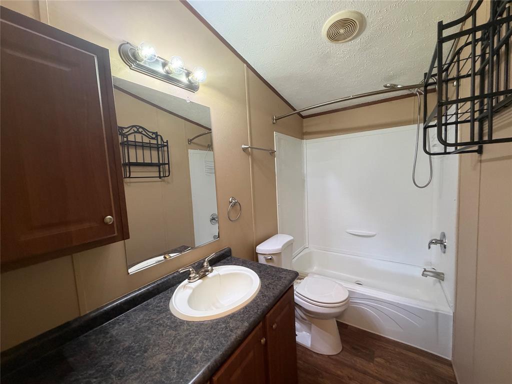 985 Indian Gap Quitman, TX 75783 - Photo 10 of 20 a bathroom with a granite countertop sink toilet a mirror and shower