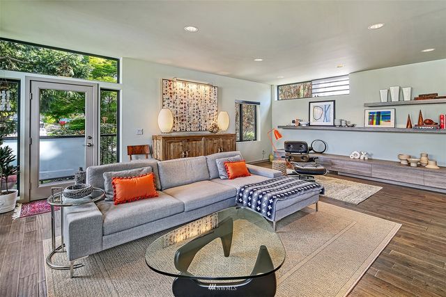 a view of a hallway with wooden floor and furniture