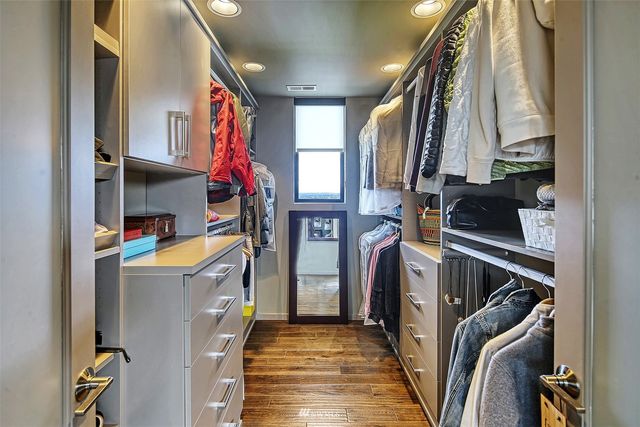 a bedroom with a bed and a large mirror on the dresser