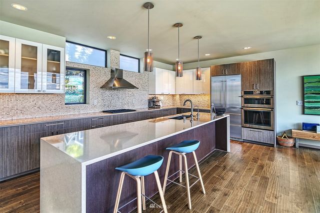 a kitchen with stainless steel appliances granite countertop a sink a stove and a refrigerator