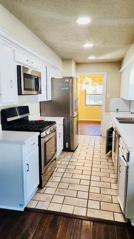 a kitchen with stainless steel appliances a stove a sink and a refrigerator