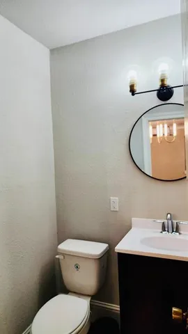 a bathroom with a toilet a sink and mirror