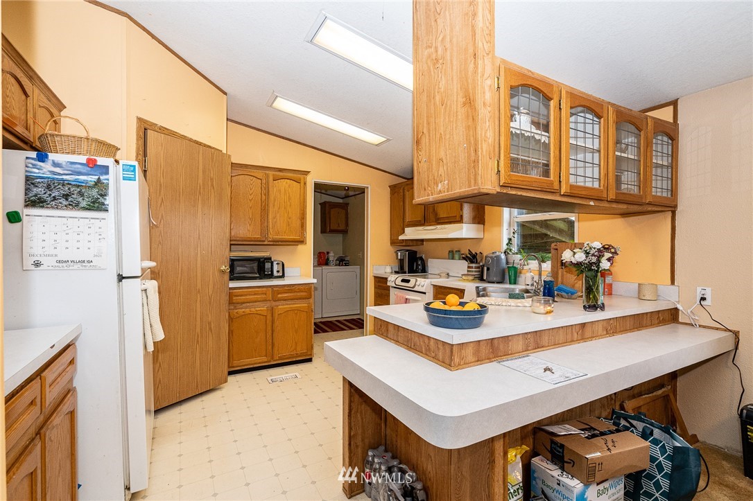 368 Jones Road Winlock, WA 98596 - Photo 17 of 39 a kitchen with a refrigerator a stove a sink and a dining table with wooden floor