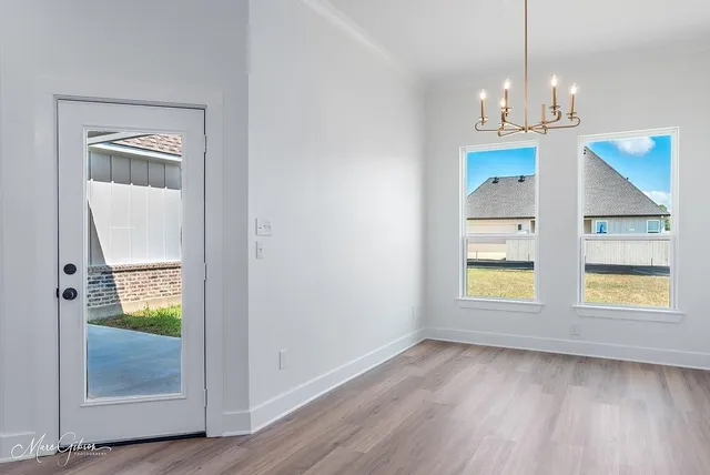 a view of empty room with wooden floor and fireplace