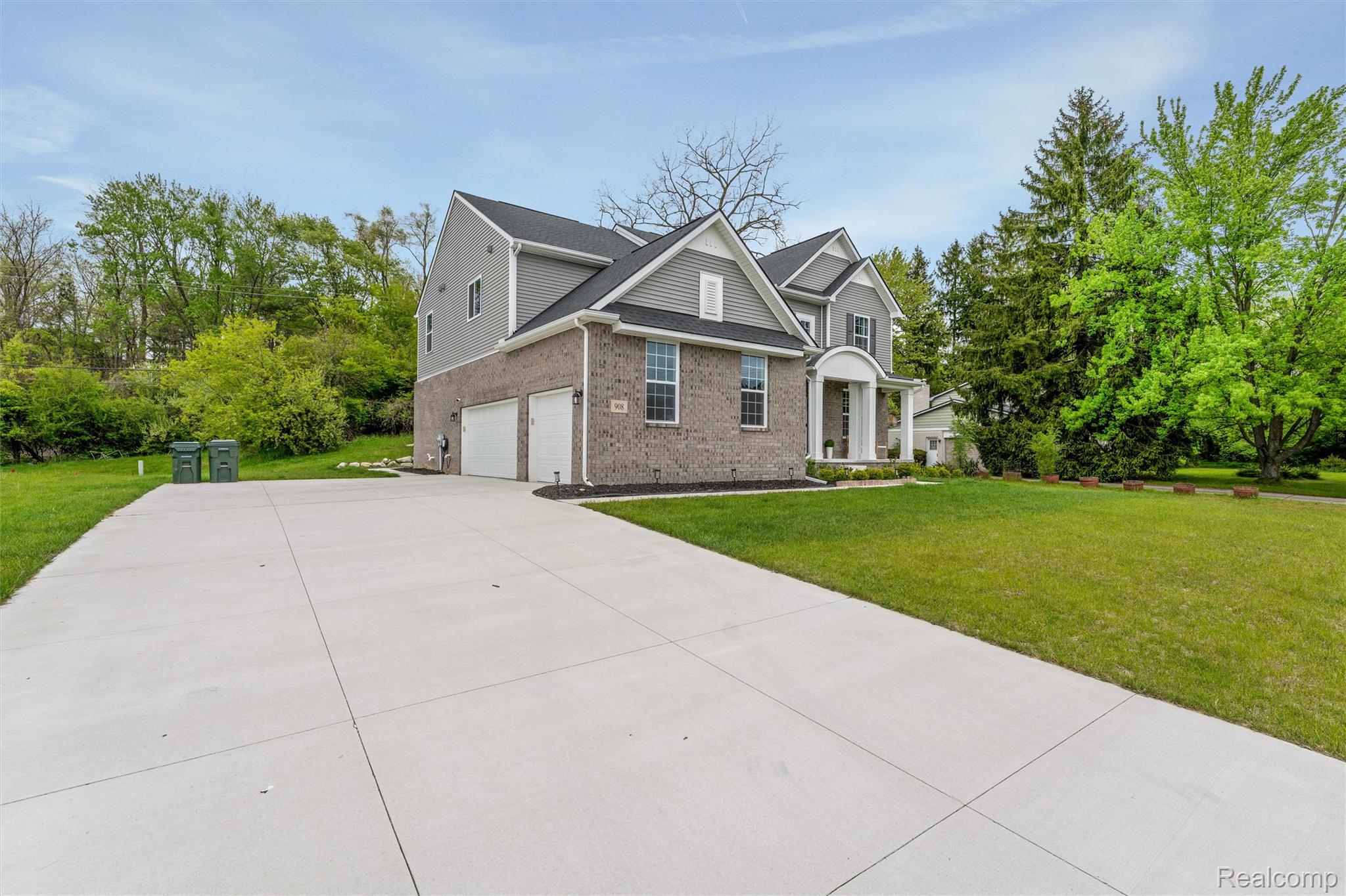 908 South Livernois Road Rochester, MI 48309 - Photo 43 of 49 Traditional home with a front yard, brick siding, concrete driveway, a garage, and view of scattered trees