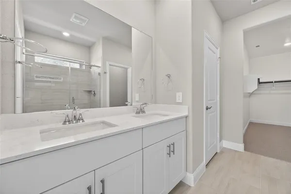 a bathroom with a sink double vanity granite tub and shower