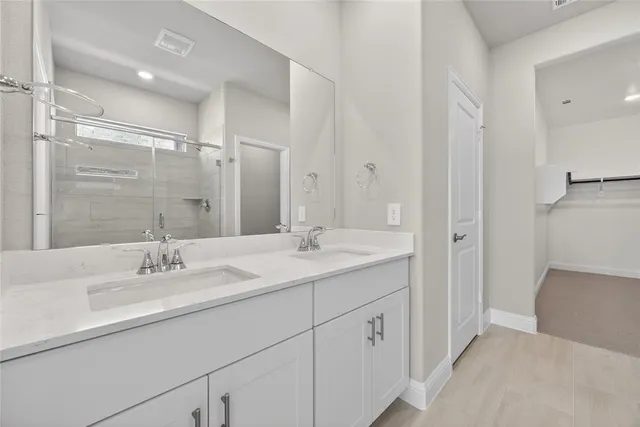 a bathroom with a sink double vanity granite tub and shower