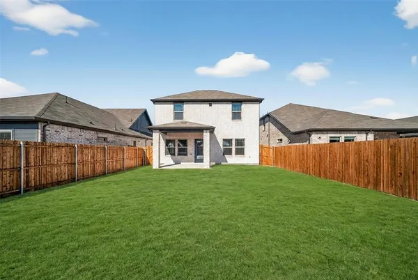 a front view of house with yard and trees in the background