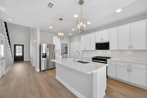 a kitchen with stainless steel appliances a refrigerator stove and microwave