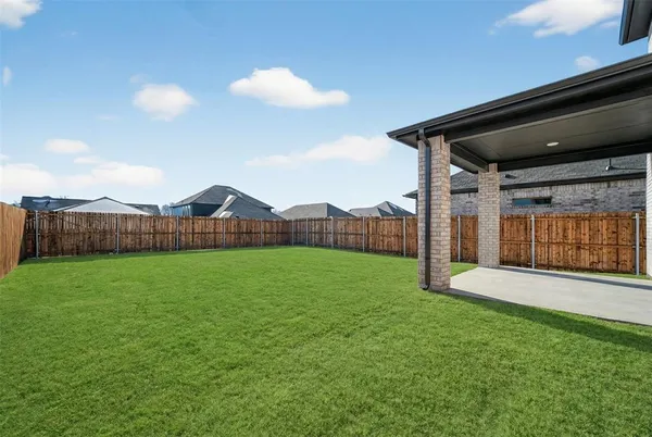 a view of a yard in front of a house with large trees