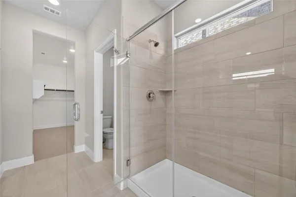 a bathroom with a shower and a glass door