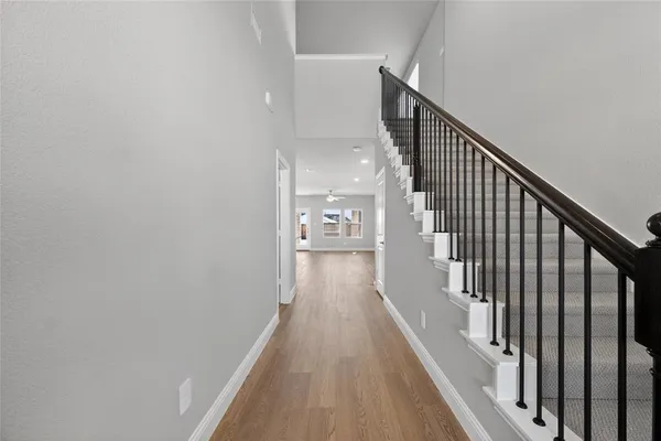 a view of a hallway with wooden floor and staircase