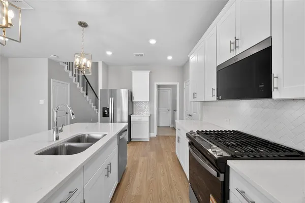 a kitchen with a sink a stove and cabinets