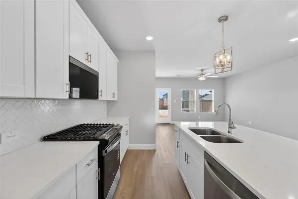 a kitchen that has a sink and a stove in it