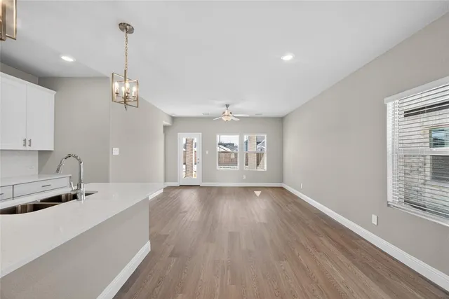 a view of a kitchen with sink and dishwasher with wooden floor