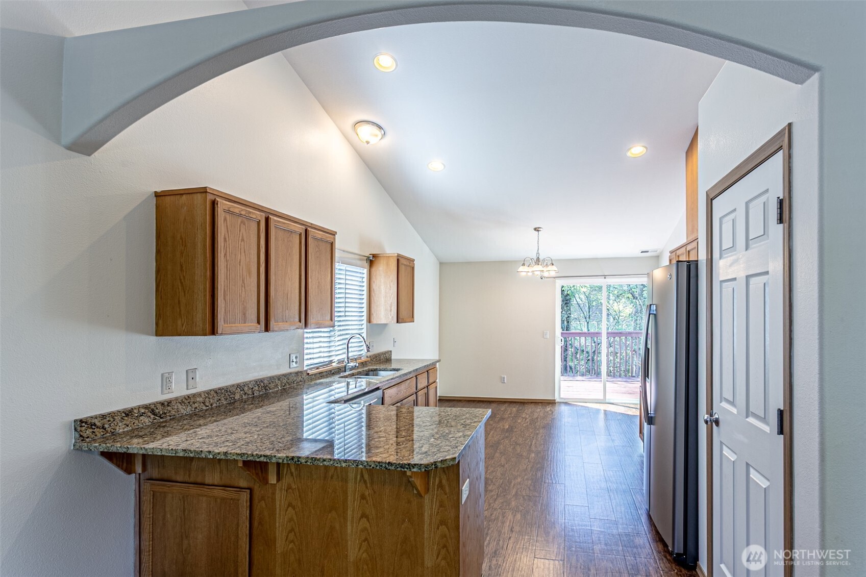 8342 49th Loop Southeast Olympia, WA 98513 - Photo 7 of 24 a kitchen with stainless steel appliances granite countertop a sink and wooden floor