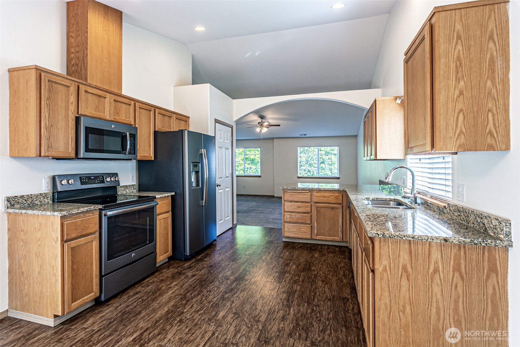 8342 49th Loop Southeast Olympia, WA 98513 - Photo 8 of 24 a kitchen with stainless steel appliances granite countertop a stove a sink and a refrigerator