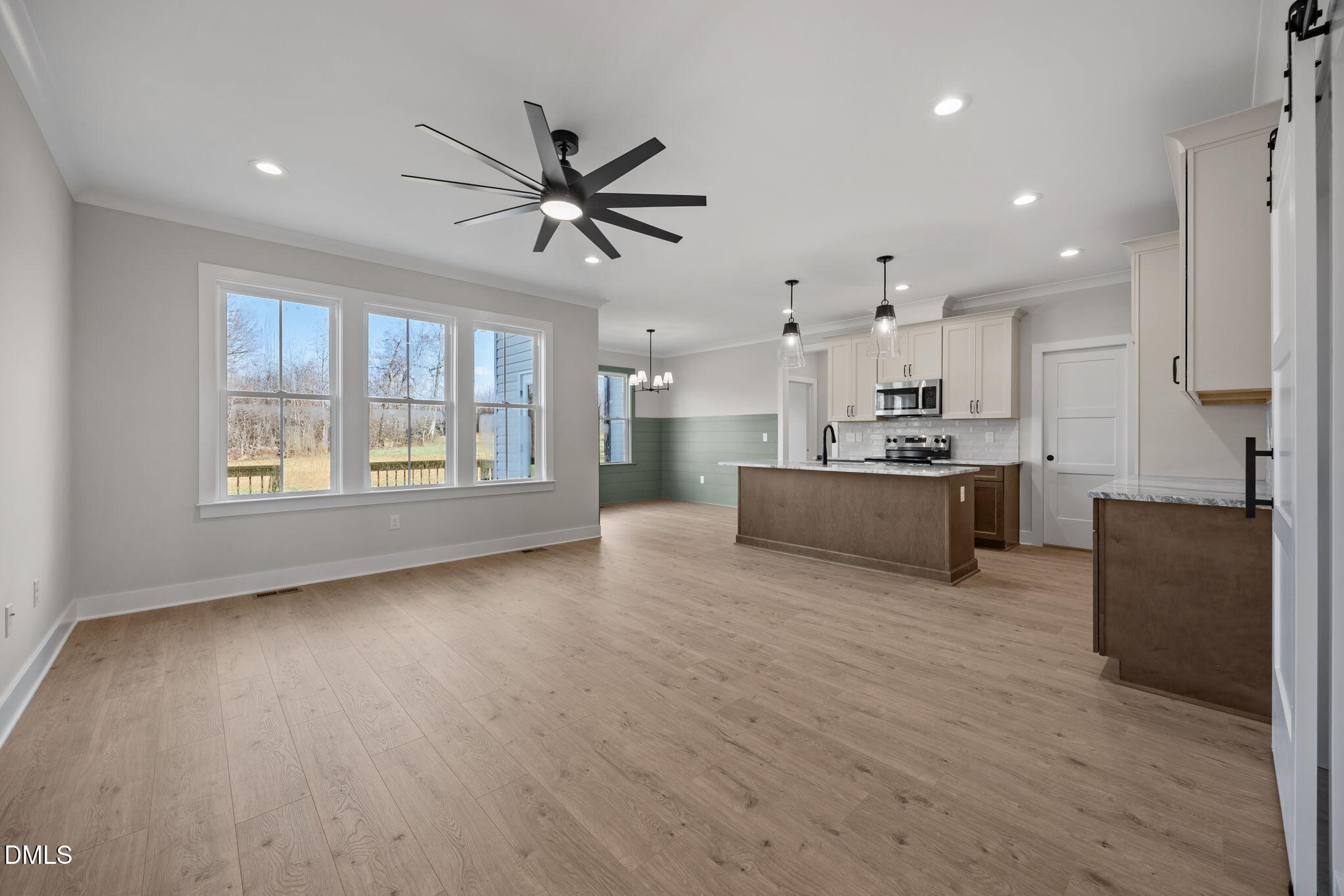 1225 Antioch Church Road Timberlake, NC 27583 - Photo 5 of 45 a view of a kitchen with kitchen island wooden floors stainless steel appliances and a window