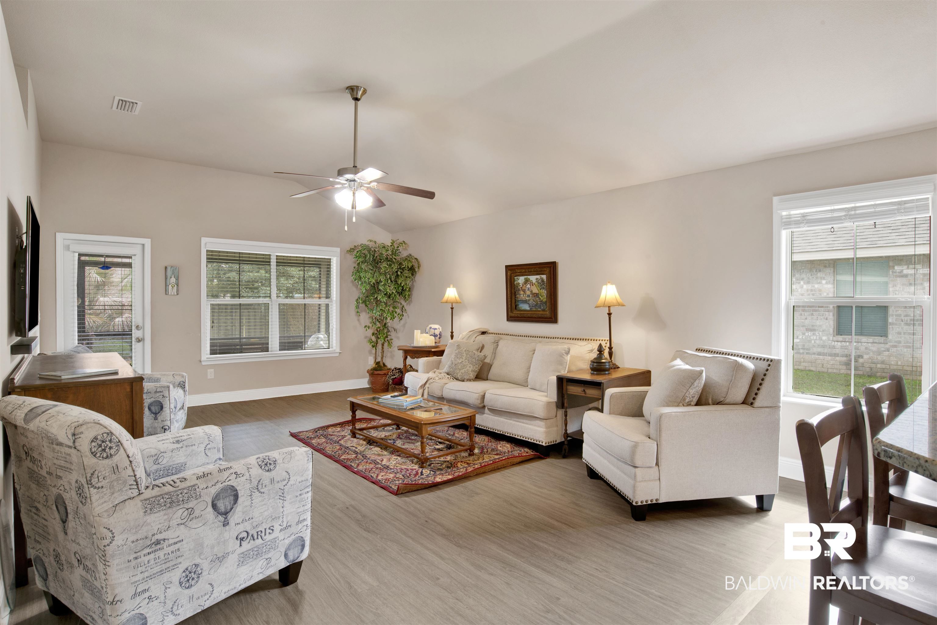22056 Garland Loop Silverhill, AL 36576 - Photo 10 of 28 Living area featuring visible vents, baseboards, wood finished floors, a ceiling fan, and vaulted ceiling