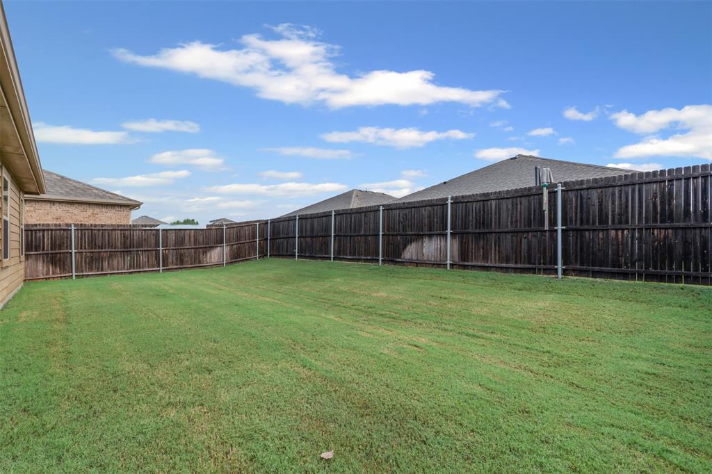 1104 Ruby Court Princeton, TX 75407 - Photo 19 of 40 a view of a yard with a wooden fence