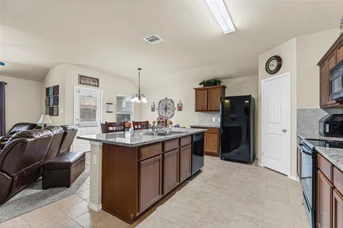 a living room with furniture kitchen view and a chandelier