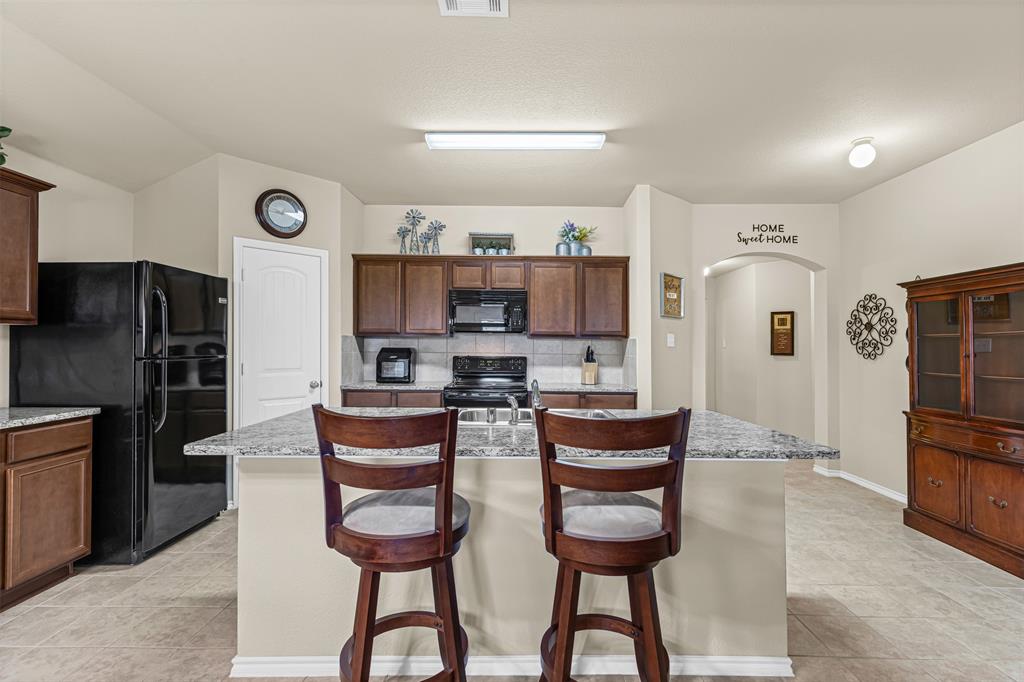 1104 Ruby Court Princeton, TX 75407 - Photo 5 of 40 a kitchen with stainless steel appliances granite countertop a refrigerator and a stove top oven