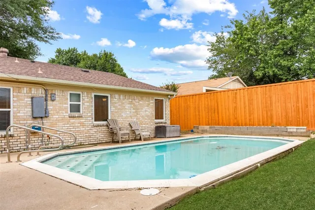 a view of a house with pool and chairs