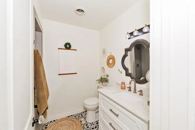 a bathroom with a sink a toilet and a mirror