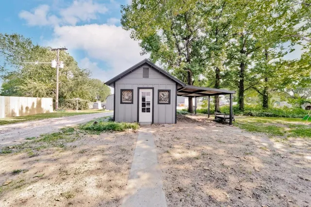 a view of a house with a yard and large tree