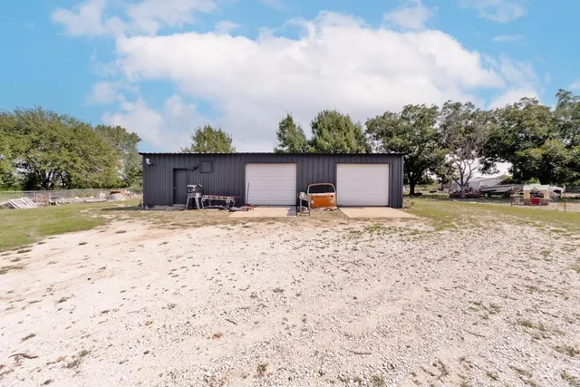a front view of a house with a yard and covered with snow