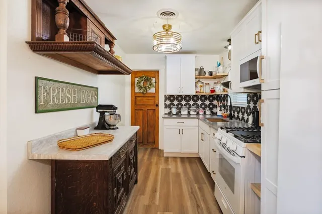 a kitchen with stainless steel appliances granite countertop a stove and cabinets