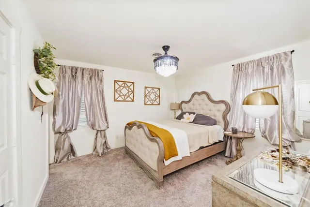 a spacious bedroom with a bed and a chandelier