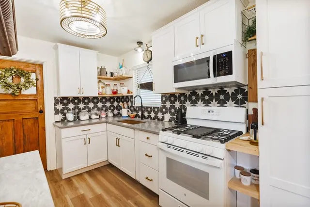 a kitchen with stainless steel appliances a stove a sink and a microwave