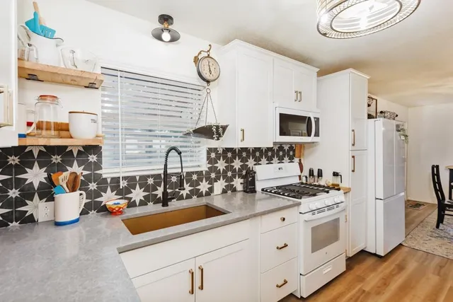 a kitchen with stainless steel appliances a sink stove and refrigerator
