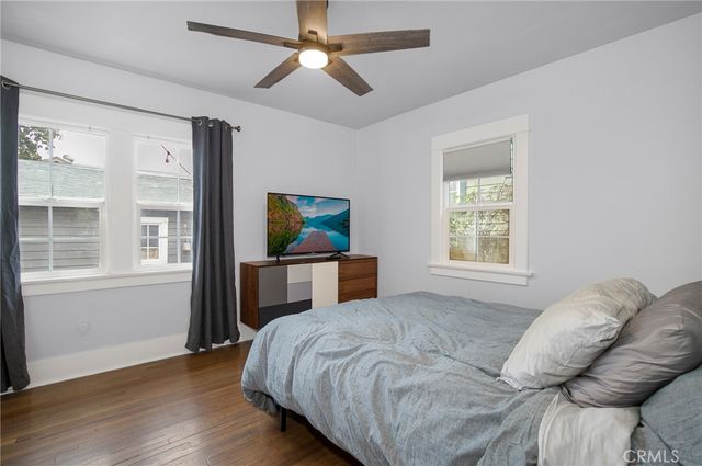 a bedroom with a bed a window and a chandelier
