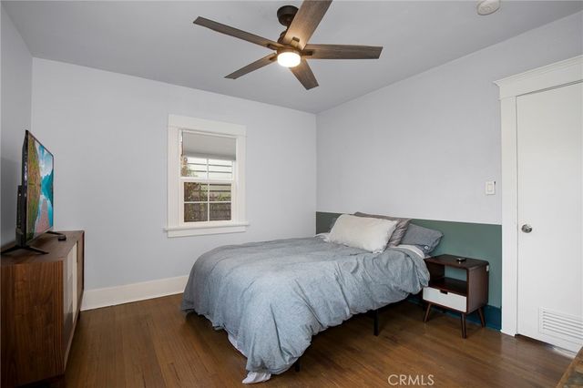 a bedroom with a bed and a flat tv screen on the dresser