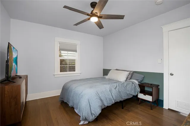 a bedroom with a bed and a flat tv screen on the dresser