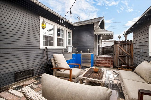 a view of a patio with couches table and chairs and potted plants
