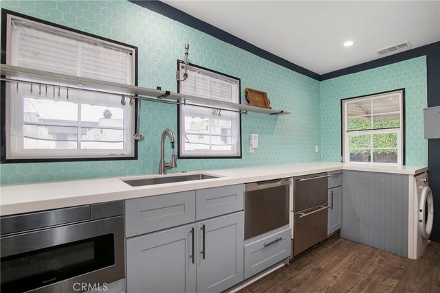a kitchen with stainless steel appliances sink and window