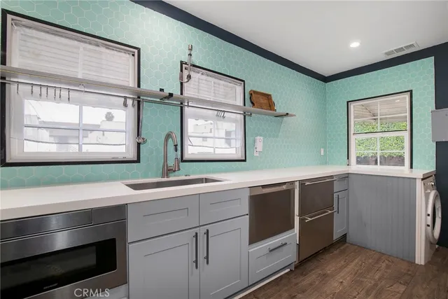 a kitchen with stainless steel appliances sink and window